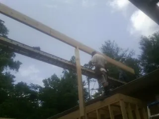 Carpenter setting a ridge beam over a new addition frame — Ice Dam Removal by Roofing Brothers in Sebastopol