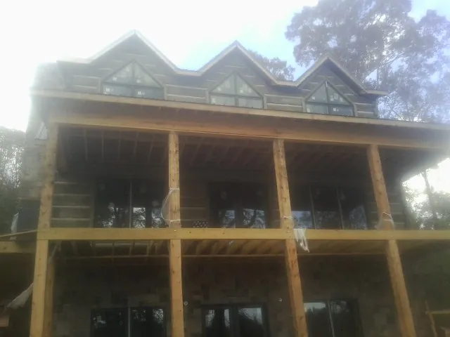 Dormers and porch framing on a large log home under construction — Roof Coating work by our crew in Sebastopol